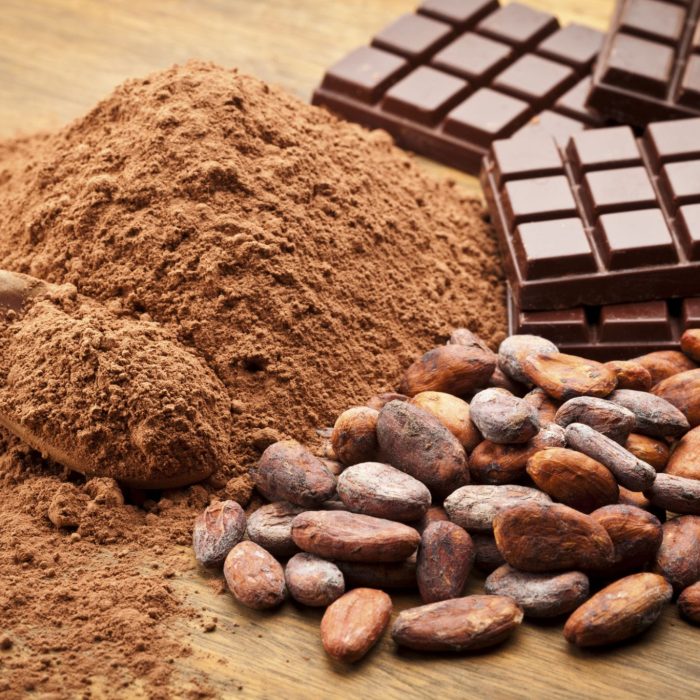 Cocoa Beans and Cocoa Powder with Chocolate Bars on Wood Table.